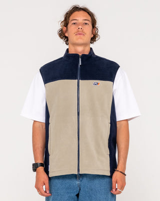 Man wearing On The Run Tech Fleece Vest in Abbey Stone