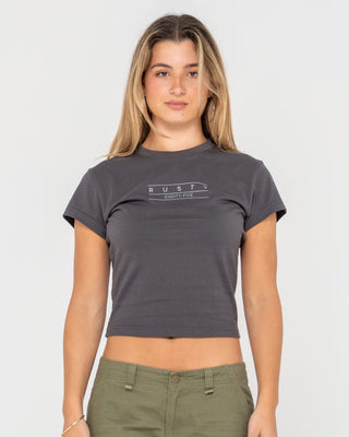 Woman wearing Rusty Essentials Skimmer Baby Tee in Carbon