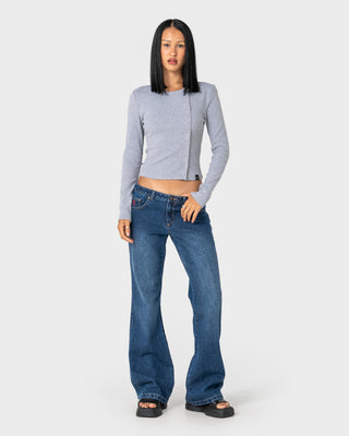 Woman wearing Shorty Freida Flare Low Rise Jeans in Blasted Deep Sea Blue