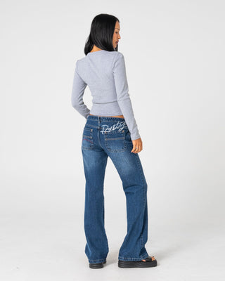 Woman wearing Shorty Freida Flare Low Rise Jeans in Blasted Deep Sea Blue