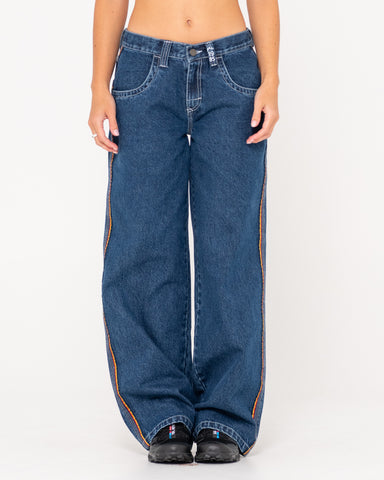 Woman wearing Flip Mommy Low Rise Wide Leg Denim Jean in Deep Sea Blue / Red Gold