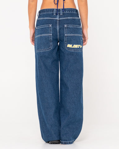 Woman wearing Flip Mommy Low Rise Wide Leg Denim Jean in Deep Sea Blue / Red Gold