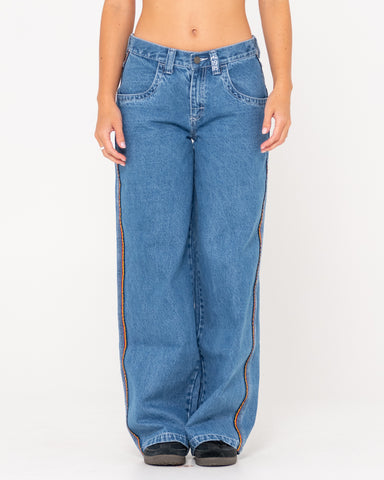 Woman wearing Flip Mommy Low Rise Wide Leg Denim Jean in Sea Blue/red Gold