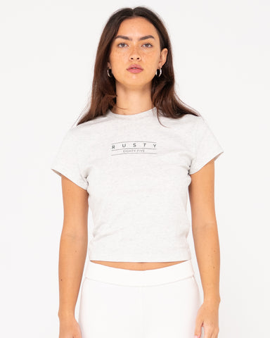 Woman wearing Rusty Essentials Skimmer Baby Tee in Ecru Marle