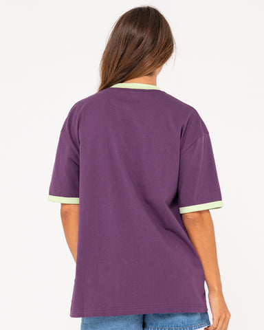 Woman wearing Boarding Pass Oversize Short Sleeve Tee in Purple Rain