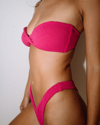 Woman wearing Sandalwood Bandeau Twist Bikini Top in Fuchsia