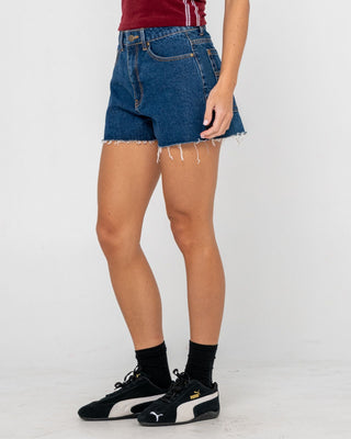 Woman wearing Penny Kick Flare Denim Short in Deep Sea Blue