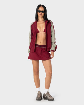 Woman wearing Breezy Wind Cheater Zip Through Jacket in Cranberry
