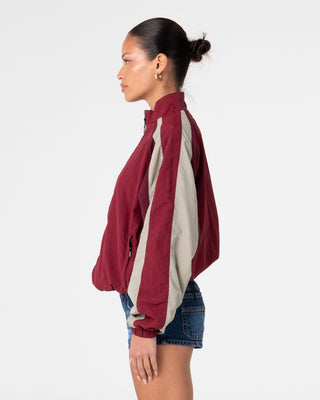 Woman wearing Breezy Wind Cheater Zip Through Jacket in Cranberry