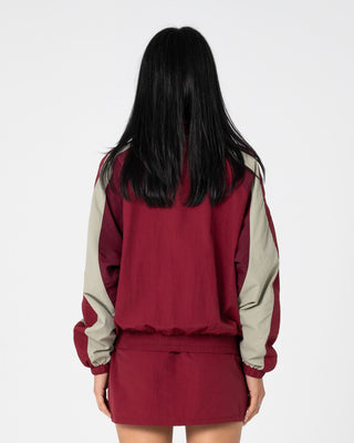 Woman wearing Breezy Wind Cheater Zip Through Jacket in Cranberry