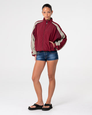Woman wearing Breezy Wind Cheater Zip Through Jacket in Cranberry