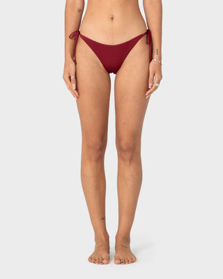 Woman wearing Cedar Midi Side Ties Bikini Bottom in Cranberry