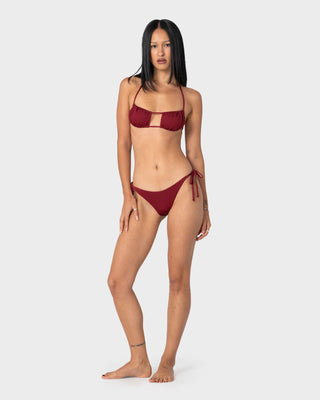 Woman wearing Cedar Midi Side Ties Bikini Bottom in Cranberry