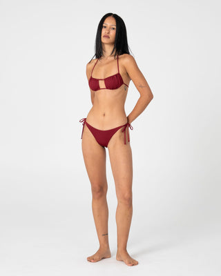 Woman wearing Cedar Midi Side Ties Bikini Bottom in Cranberry