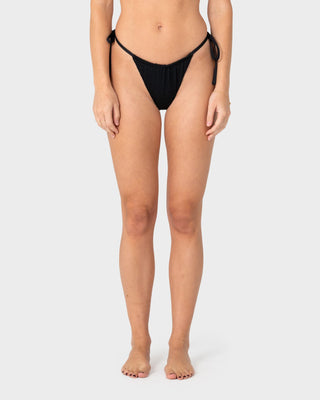 Woman wearing Cedar Cheeky Side Ties Bikini Bottom in Black