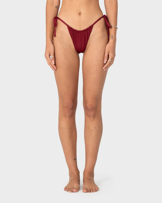 woman-wearing-cedar-cheeky-side-ties-bikini-bottom-in-cranberry