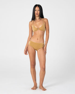 Woman wearing Shimmy Cheeky Bikini Short in Gold