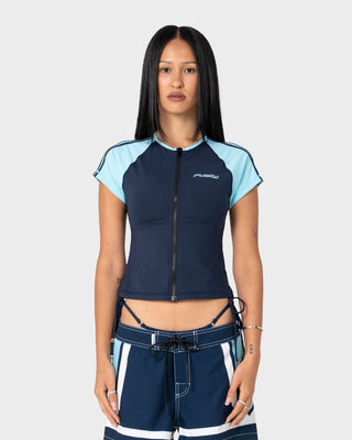 Woman wearing Mel Sea S/S Zip Through Rash Vest in Navy / Aqua