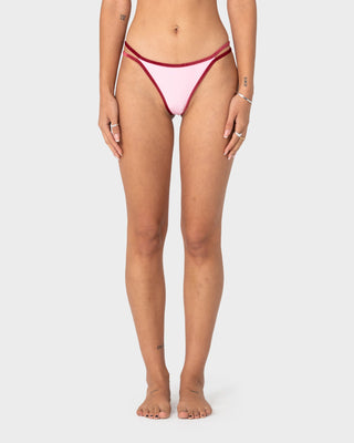 Woman wearing Sugary Brazilian Bikini Bottom in Pink / Red