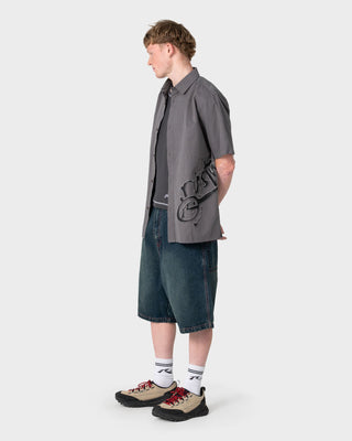 Man wearing Spray N Pray Short Sleeve Shirt in Steel