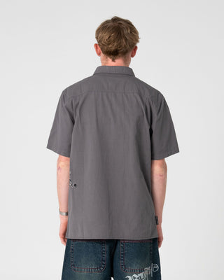 Man wearing Spray N Pray Short Sleeve Shirt in Steel