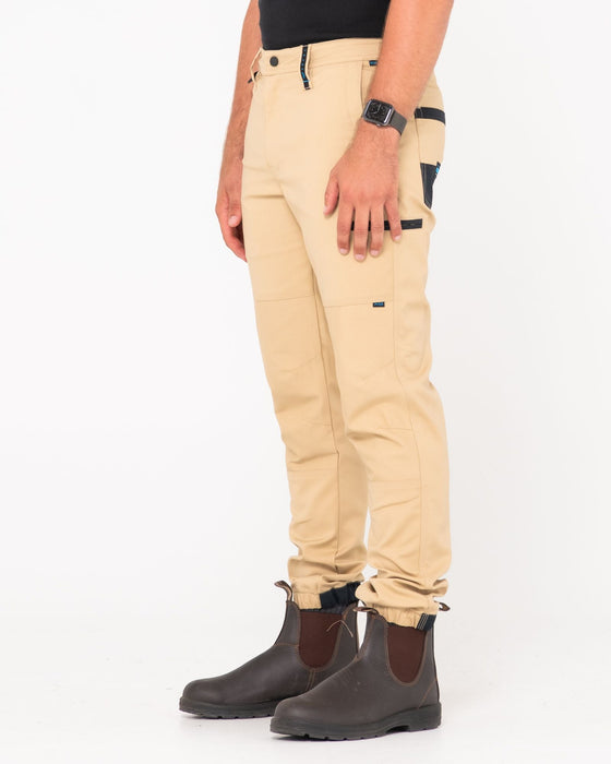 man-wearing-tr246-9-pocket-stretch-work-pant-cuffed-in-trade-khaki