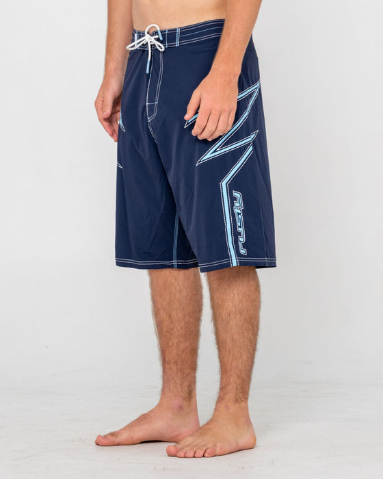 man-wearing-slasher-fixed-waist-boardshort-in-navy-blue