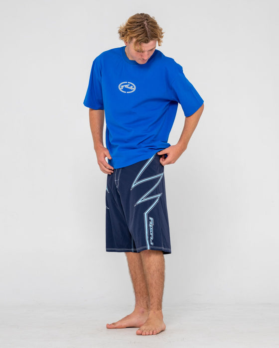 man-wearing-slasher-fixed-waist-boardshort-in-navy-blue