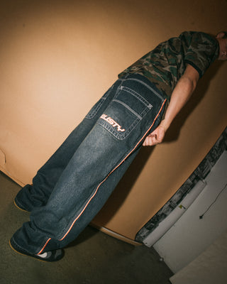 Man wearing Flip Daddy 2.0 Jean in Dark N Dirty / Orange