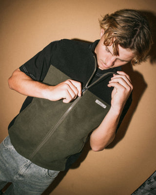 Man wearing On The Run Tech Fleece Vest in Army Green