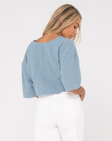 Woman wearing Somewhere Twisted Reversible Top in Dusty Blue