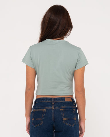 Woman wearing Rusty Signature Skimmer Baby Tee in Faded Pistachio